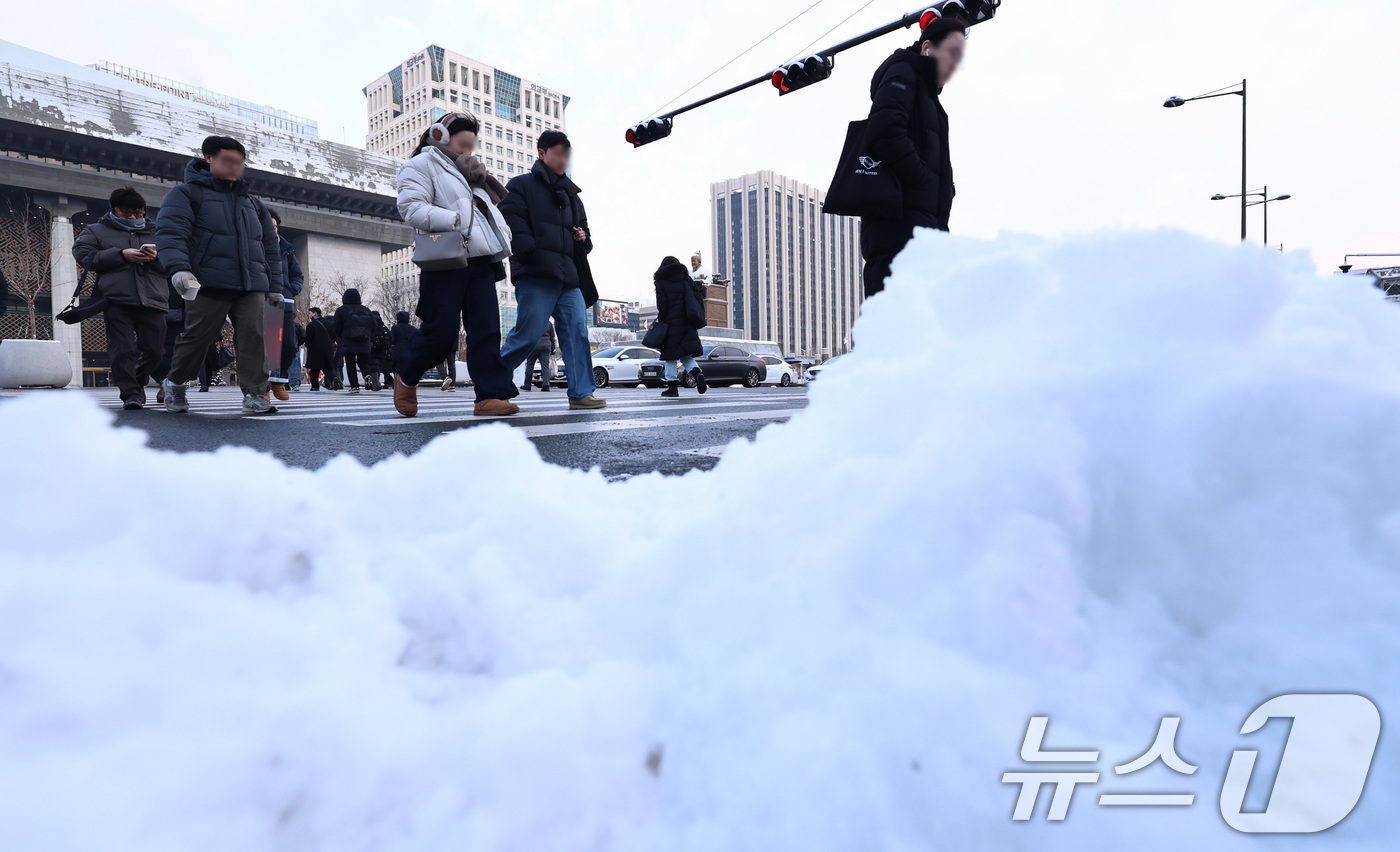 (서울=뉴스1) 구윤성 기자 = 2일 오전 서울 종로구 세종대로에서 밤새 내려 쌓인 눈 뒤로 출근길 시민들이 발걸음을 옮기고 있다. 2026.2.2/뉴스1