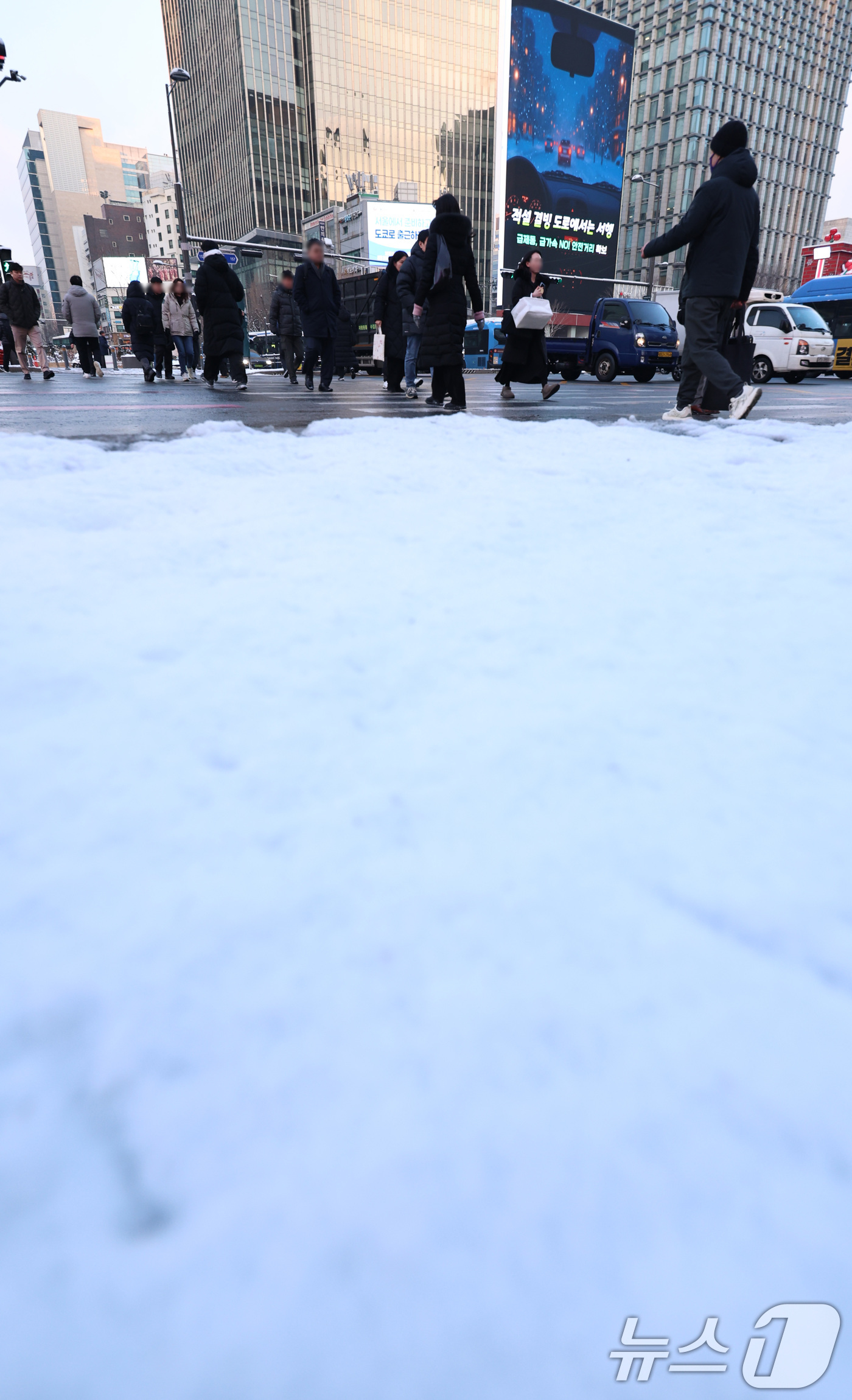 (서울=뉴스1) 구윤성 기자 = 2일 오전 서울 종로구 세종대로에서 밤새 내려 쌓인 눈 뒤로 출근길 시민들이 발걸음을 옮기고 있다. 2026.2.2/뉴스1