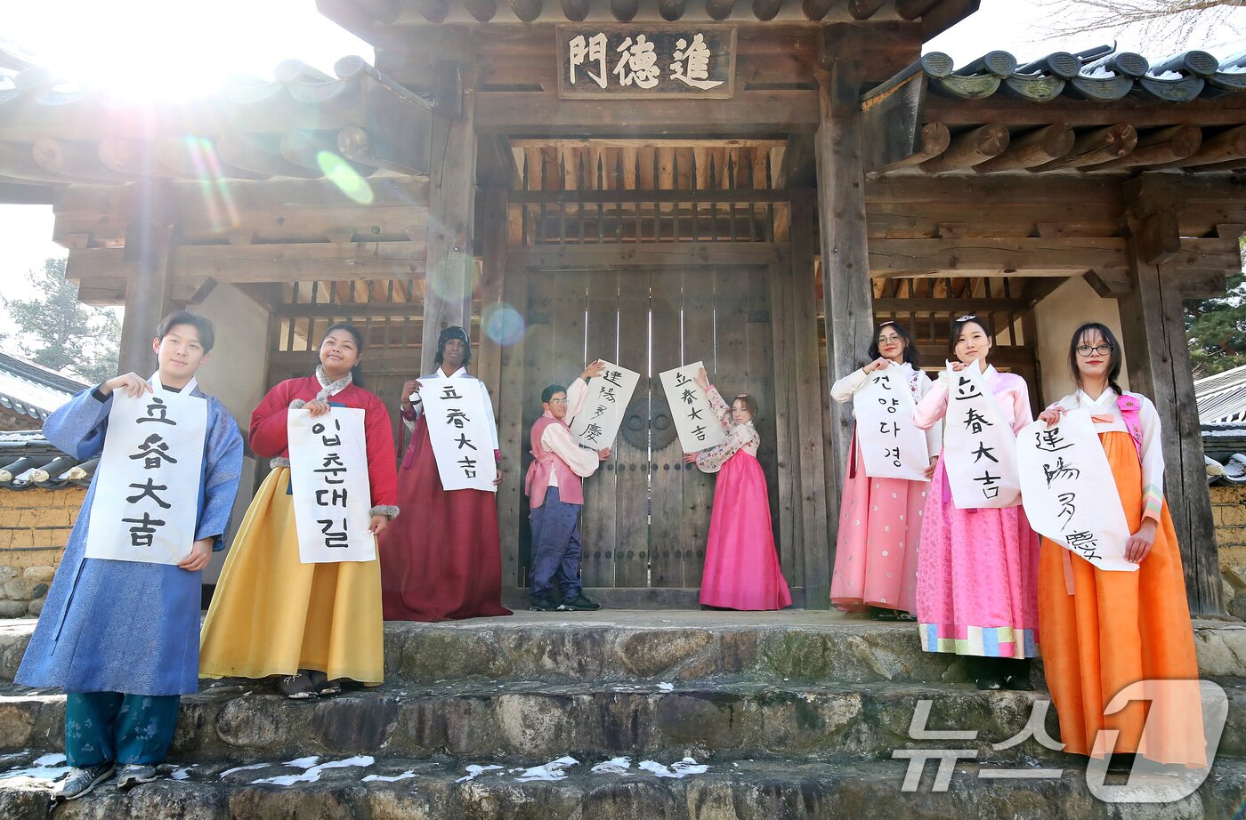 본문 이미지 - 봄의 시작을 알리는 절기 입춘(立春)을 이틀 앞두고 눈이 내린 2일 오전 경북 경산시 영남대 민속촌에서 한국 전통문화 체험에 참여한 외국인 유학생들이 붓글씨로 직접 쓴 입춘방을 구계서원 대문인 진덕문에 붙이고 있다. 2026.2.2/뉴스1 ⓒ News1 공정식 기자