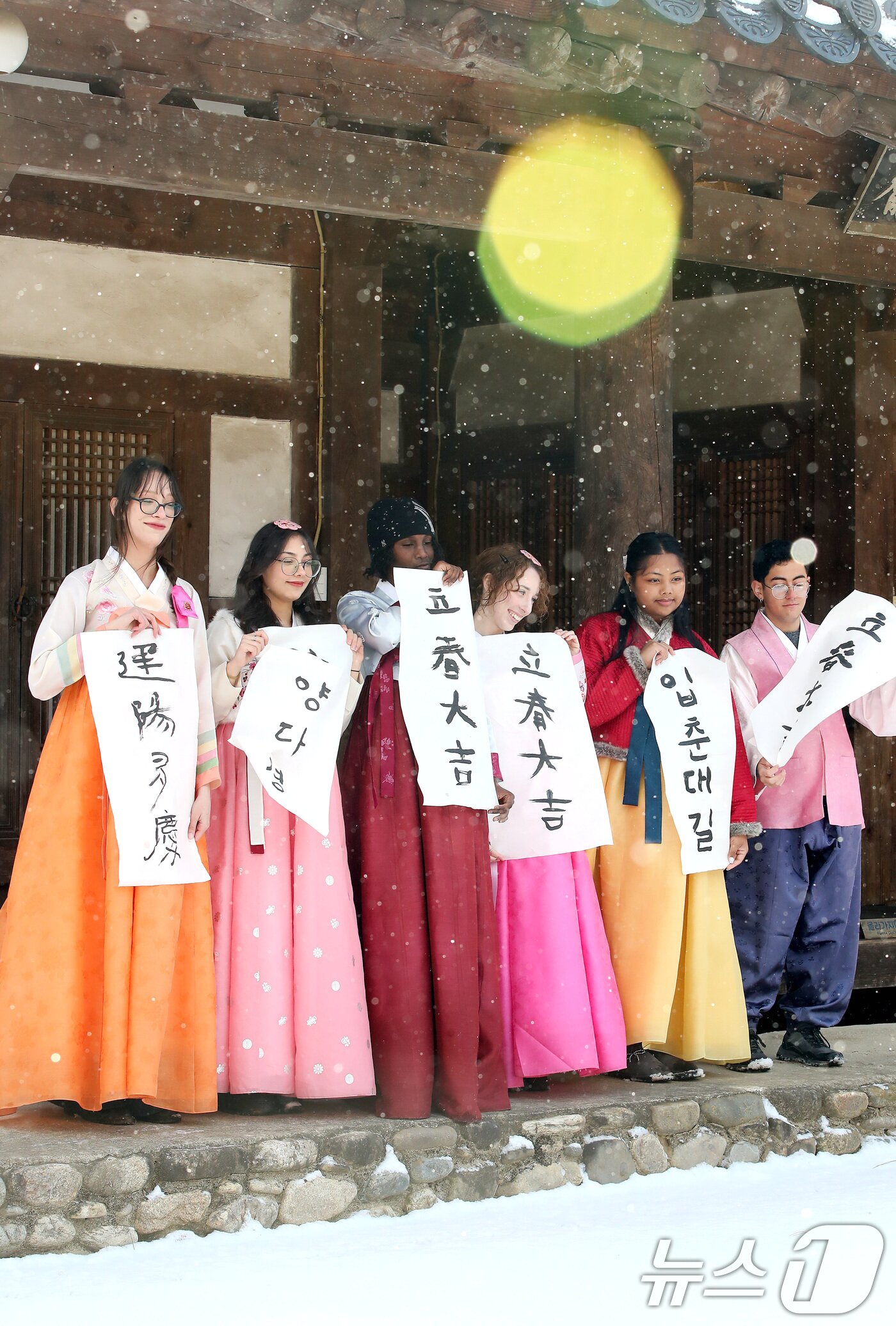 본문 이미지 - 봄의 시작을 알리는 절기 입춘(立春)을 이틀 앞두고 눈이 내린 2일 오전 경북 경산시 영남대 민속촌에서 한국 전통문화 체험에 참여한 외국인 유학생들이 붓글씨로 직접 쓴 입춘첩을 들어 보이고 있다. 2026.2.2/뉴스1 ⓒ News1 공정식 기자