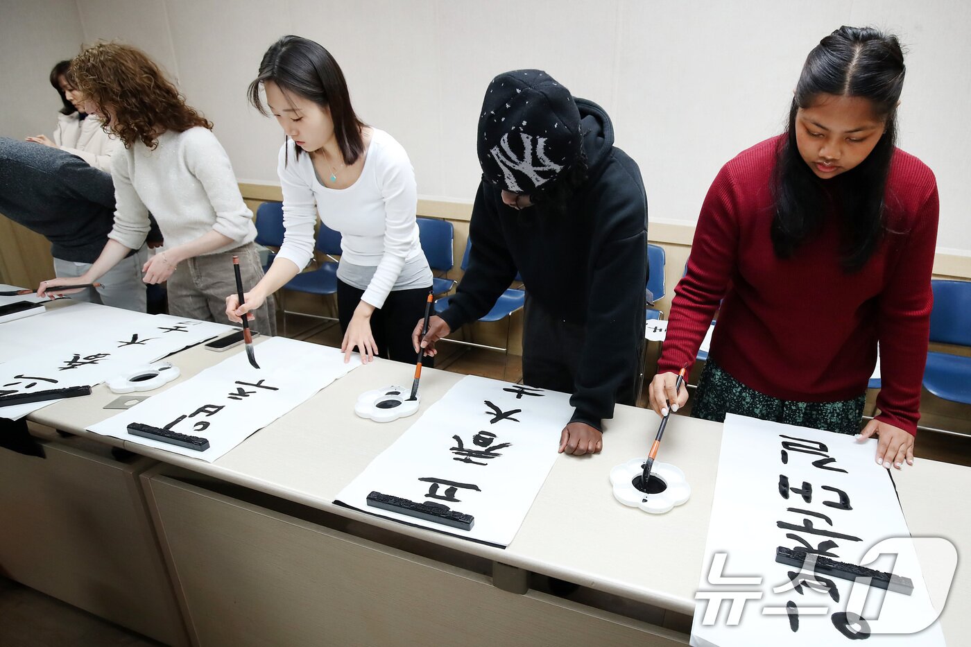 본문 이미지 - 봄의 시작을 알리는 절기 입춘(立春)을 이틀 앞두고 눈이 내린 2일 오전 경북 경산시 영남대 박물관에서 한국 전통문화 체험에 참여한 외국인 유학생들이 입춘첩 '입춘대길(立春大吉) 건양다경(建陽多慶)'을 한글과 한자 붓글씨로 쓰고 있다. 2026.2.2/뉴스1 ⓒ News1 공정식 기자