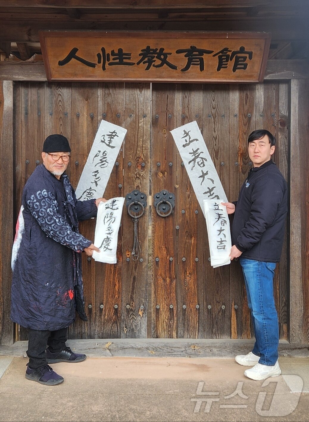 본문 이미지 - 서예가 김동욱 씨가 2일 입춘을 앞두고 경북 포항시 북구 기계면 문성리 인성 교육관 대문에 입춘첩을 붙이고 있다. (서예가 깅동욱 씨 제공) 2026.2.2/뉴스1 ⓒ News1 최창호 기자