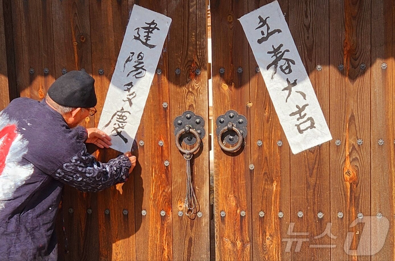 본문 이미지 - 서예가 김동욱 씨가 2일 입춘을 앞두고 경북 포항시 북구 기계면 문성리 인성 교육관 대문에 입춘첩을 붙이고 있다. (서예가 깅동욱 씨 제공) 2026.2.2/뉴스1 ⓒ News1 최창호 기자