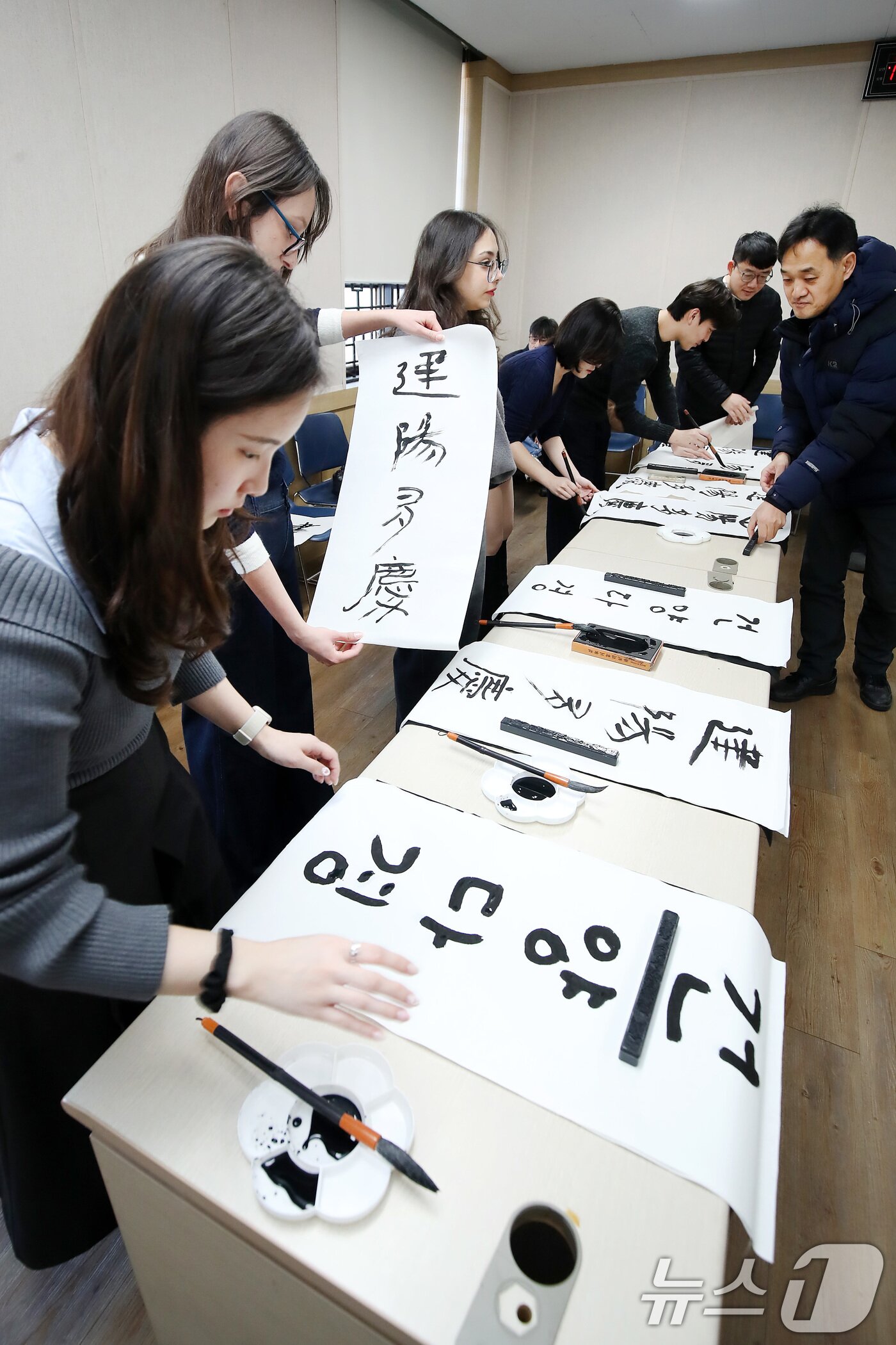 본문 이미지 - 봄의 시작을 알리는 절기 입춘(立春)을 이틀 앞두고 눈이 내린 2일 오전 경북 경산시 영남대 박물관에서 한국 전통문화 체험에 참여한 외국인 유학생들이 입춘첩 '입춘대길(立春大吉) 건양다경(建陽多慶)'을 한글과 한자 붓글씨로 쓰고 있다. 2026.2.2/뉴스1 ⓒ News1 공정식 기자