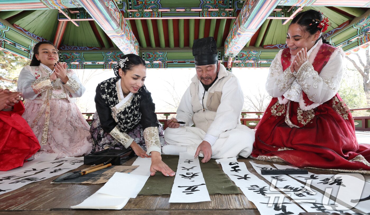 본문 이미지 - 절기상 입춘(立春)을 이틀 앞둔 2일 경기 용인시 기흥구 한국민속촌에서 외국인 관광객들이 입춘첩을 보며 신기해 하고 있다. 2026.2.2/뉴스1 ⓒ News1 김영운 기자