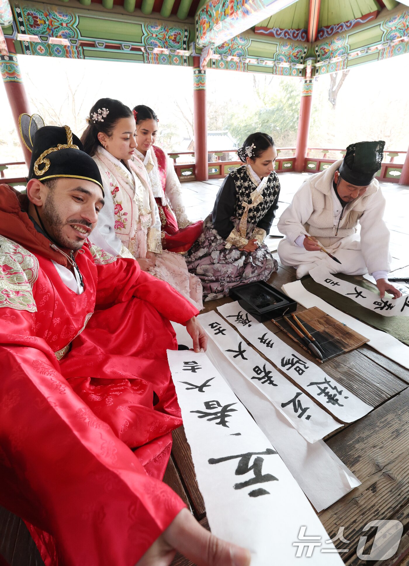 본문 이미지 - 절기상 입춘(立春)을 이틀 앞둔 2일 경기 용인시 기흥구 한국민속촌에서 외국인 관광객들이 입춘첩을 보며 신기해 하고 있다. 2026.2.2/뉴스1 ⓒ News1 김영운 기자