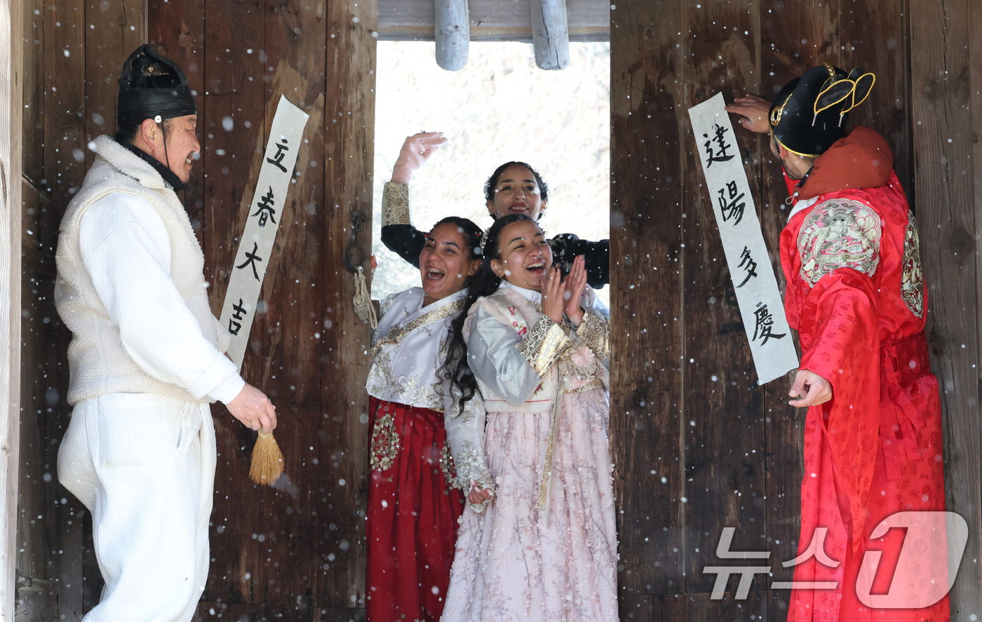 (용인=뉴스1) 김영운 기자 = 절기상 입춘(立春)을 이틀 앞둔 2일 경기 용인시 기흥구 한국민속촌에서 외국인 관광객들이 입춘첩을 보며 신기해 하고 있다. 2026.2.2/뉴스1