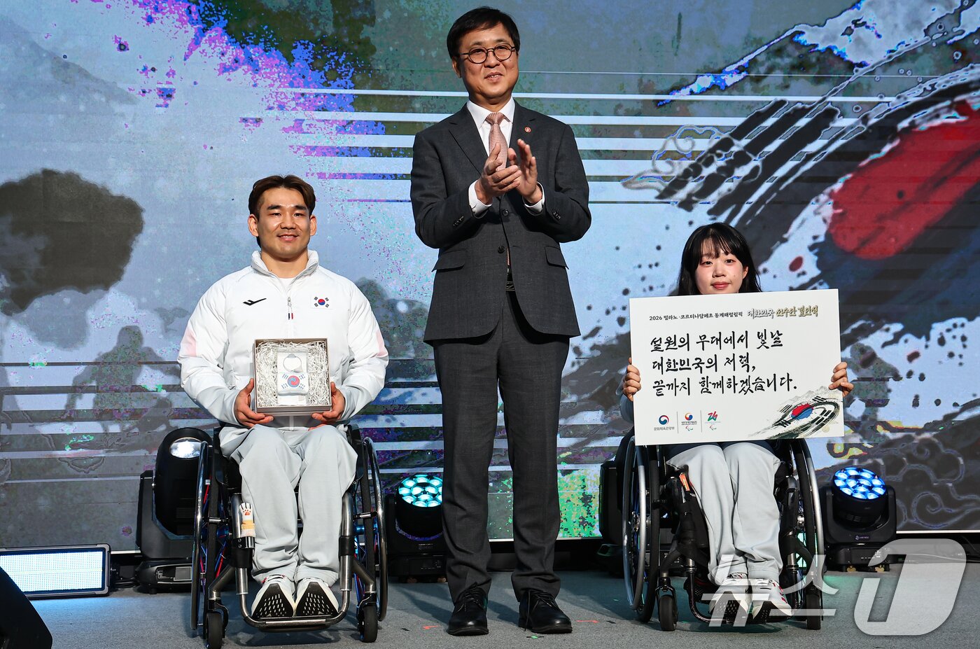 본문 이미지 - 최휘영 문체부 장관이 2일 서울 송파구 올림픽파크텔에서 열린 2026 밀라노·코르티나담페초 동계 패럴림픽 대한민국 선수단 결단식에서 이용석, 김윤지 선수에게 격려선물 전달 후 기념촬영을 하고 있다. 2026.2.2/뉴스1 ⓒ News1 김도우 기자