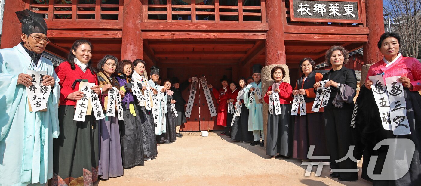 본문 이미지 - 절기상 입춘(立春)을 이틀 앞둔 2일 오후 부산 동래향교에서 지역 유림 대표들이 입춘첩을 대문에 붙이고 있다. ⓒ News1 윤일지 기자