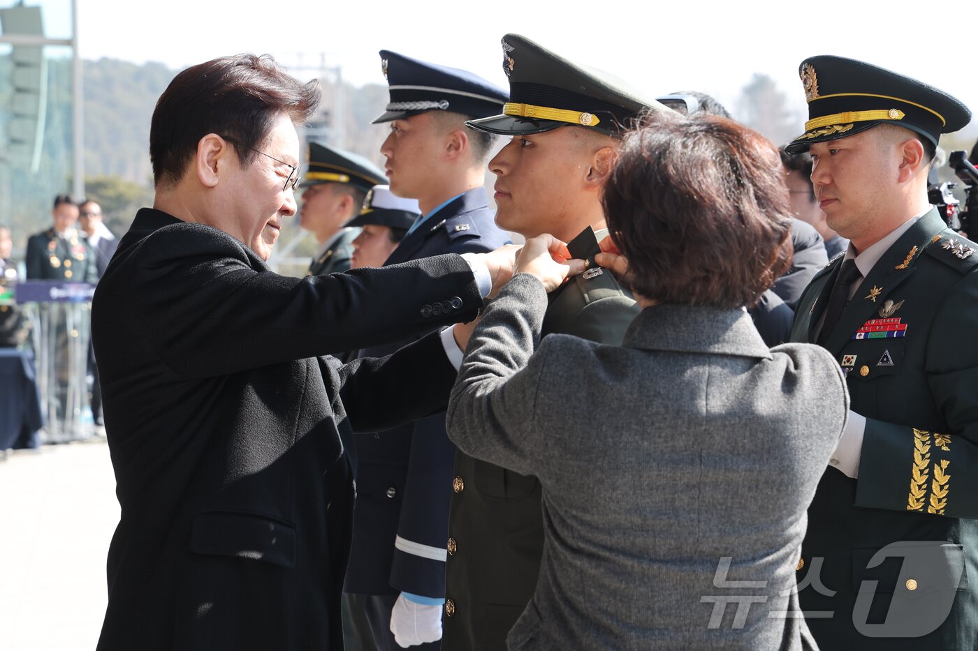 본문 이미지 - 이재명 대통령이 20일 충남 계룡대 대연병장에서 열린 육·해·공군 사관학교 통합임관식에서 임관 장교에게 계급장을 달아주고 있다. 2026.2.20 ⓒ 뉴스1 이재명 기자