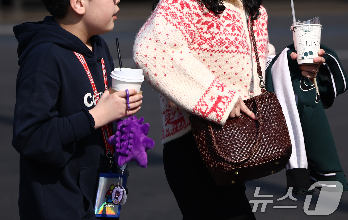 (서울=뉴스1) 김민지 기자 = 서울 낮 최고 기온이 10도 이상 오르며 포근한 날씨를 보인 20일 오후 서울 광화문 사거리에서 시민이 외투를 들고 발걸음을 옮기고 있다. 2026 …