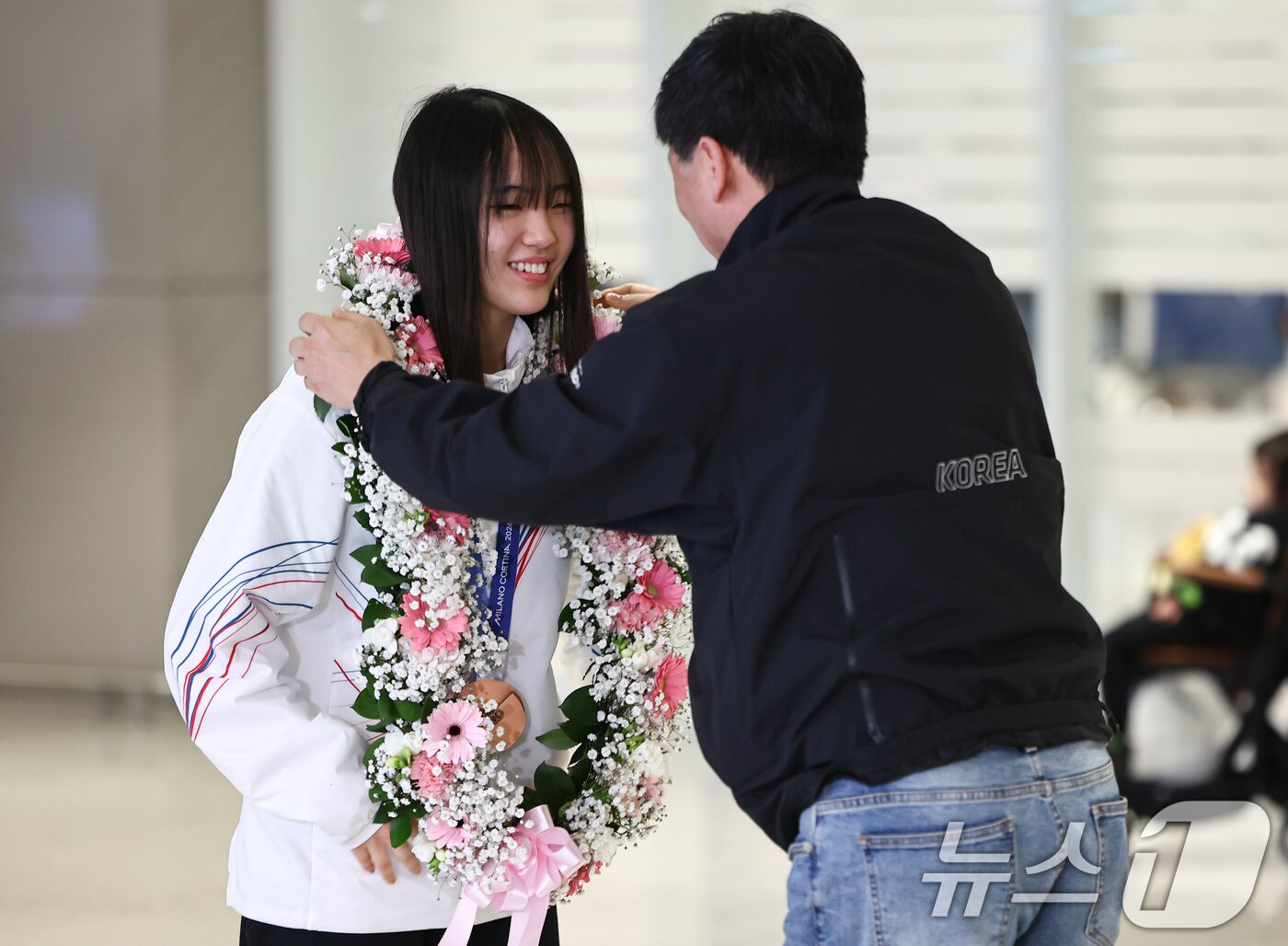 본문 이미지 - 2026 밀라노·코르티나담페초 동계올림픽 스노보드 빅에어에서 동메달을 차지한 유승은이 21일 인천공항2터미널을 통해 귀국해 꽃목걸이를 받고 있다. 2026.2.21 ⓒ 뉴스1 김도우 기자