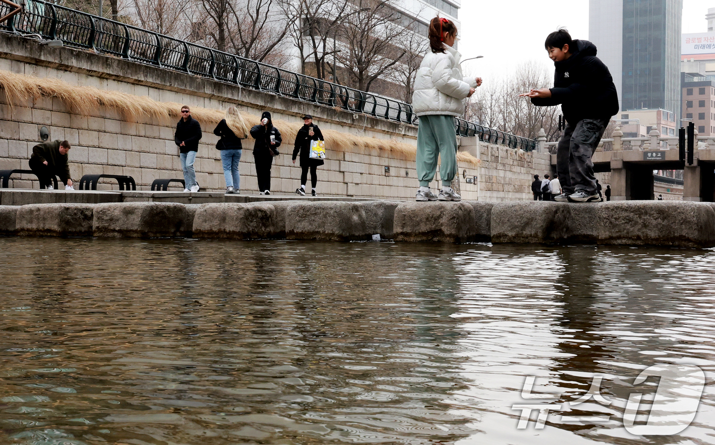 (서울=뉴스1) 이호윤 기자 = 서울 낮 최고 기온이 10도 이상 오르며 포근한 날씨를 보인 22일 오후 서울 청계천을 찾은 관광객들이 산책을 하고 있다. 2026.2.22/뉴스1 …