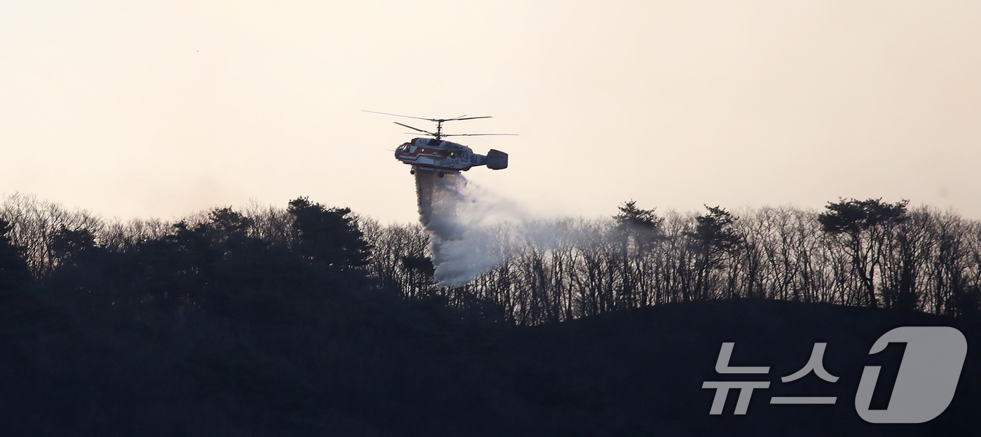 (함양=뉴스1) 윤일지 기자 = 경남 함양 산불 사흘째인 23일 오전 함양군 마천면 창원리 야산에서 산불진화 헬기가 진화 작업을 벌이고 있다. 2026.2.23/뉴스1