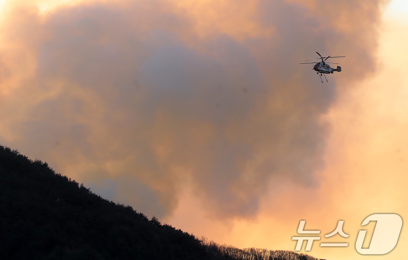 (함양=뉴스1) 윤일지 기자 = 경남 함양 산불 사흘째인 23일 오전 함양군 마천면 창원리 야산에서 산불진화 헬기가 진화 작업을 벌이고 있다. 2026.2.23/뉴스1