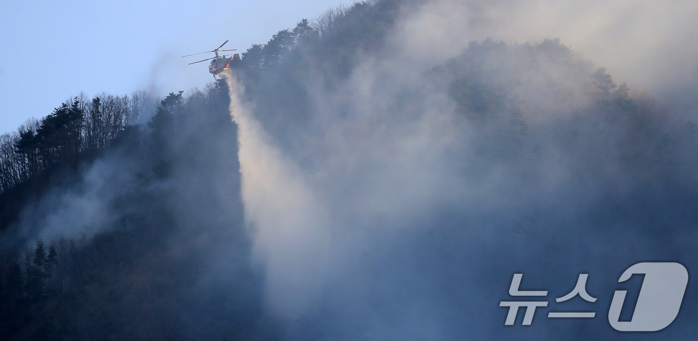(함양=뉴스1) 윤일지 기자 = 경남 함양 산불 사흘째인 23일 오전 함양군 마천면 창원리 야산에서 산불진화 헬기가 진화 작업을 벌이고 있다. 2026.2.23/뉴스1