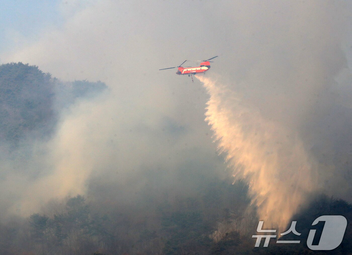 본문 이미지 - 경남 함양 산불 사흘째인 지난 2월 23일 오전 함양군 마천면 산불 현장에서 산불진화 헬기가 진화 작업을 벌이고 있다. 2026.2.23 ⓒ 뉴스1 윤일지 기자