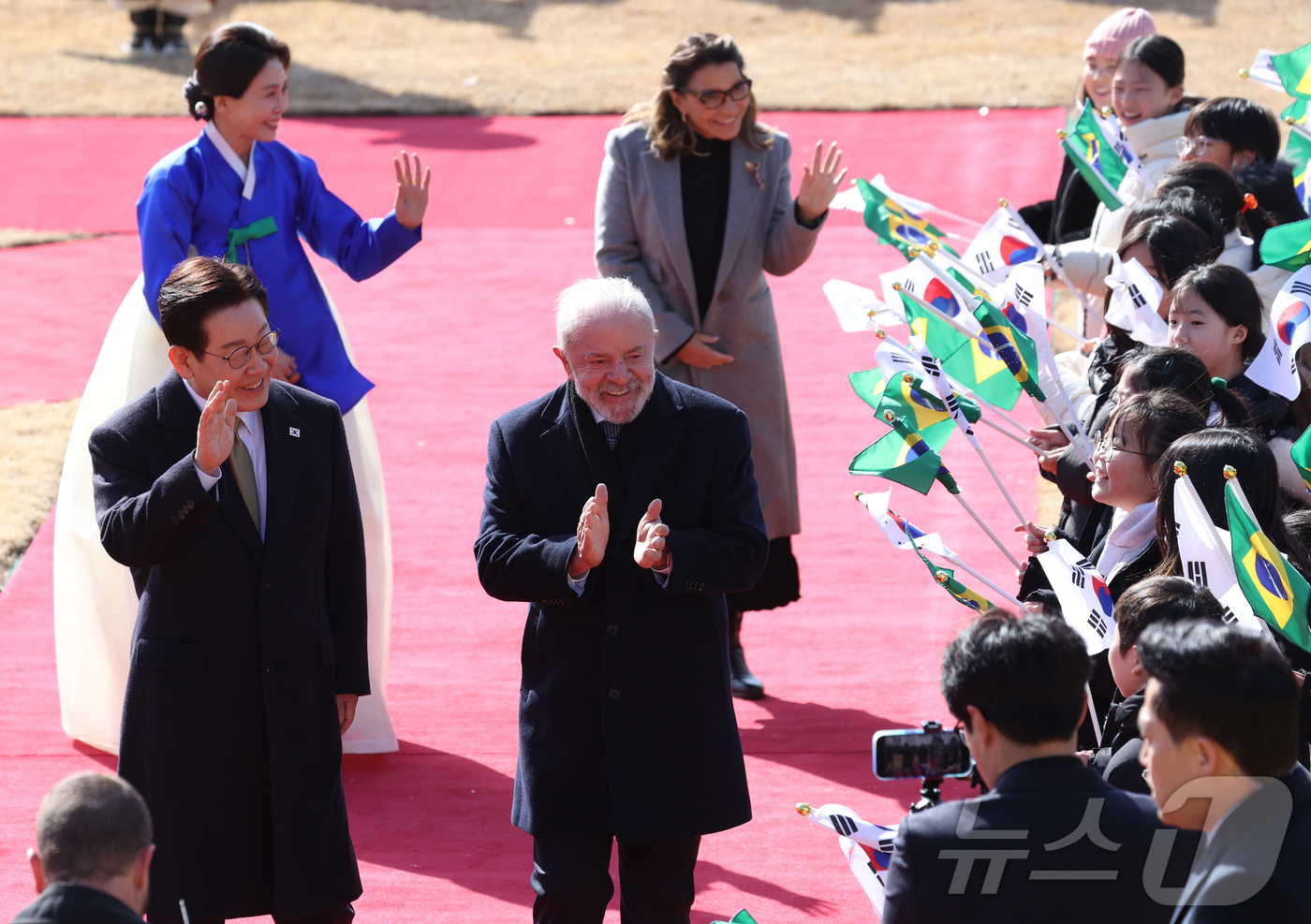 (서울=뉴스1) 허경 기자 = 이재명 대통령 부부와 루이스 이나시우 룰라 다 시우바 브라질 대통령 부부가 23일 청와대에서 열린 공식 환영식에서 어린이들에게 인사를 하고 있다. …