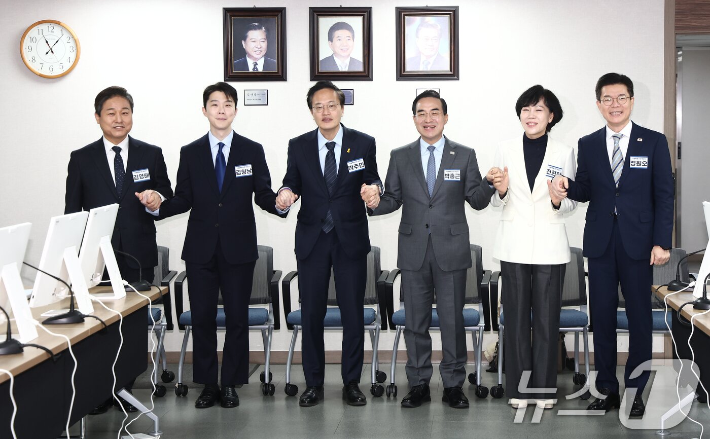 본문 이미지 - 23일 오전 서울 영등포구 더불어민주당 당사에서 열린 중앙당공천광리위원회 2차 회의 및 광역단체장 후보자 면접에서 서울시장 후보들이 손을 맞잡고 기념촬영을 하고 있다. 왼쪽부터 김영배 의원, 김형남 전 군인권센터 사무국장, 박주민·박홍근·전현희 의원, 정원오 성동구청장. 2026.2.23 ⓒ 뉴스1 김민지 기자