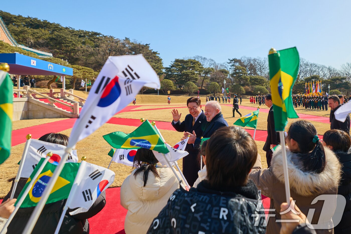 본문 이미지 - 이재명 대통령이 23일 국빈 방한한 브라질 루이스 이나시우 룰라 다 시우바 대통령과 정상회담에 앞서 열린 공식 환영식에서 어린이들에게 환영을 받고 있다. (청와대 제공. 재판매 및 DB 금지) 2026.2.23 ⓒ 뉴스1 허경 기자