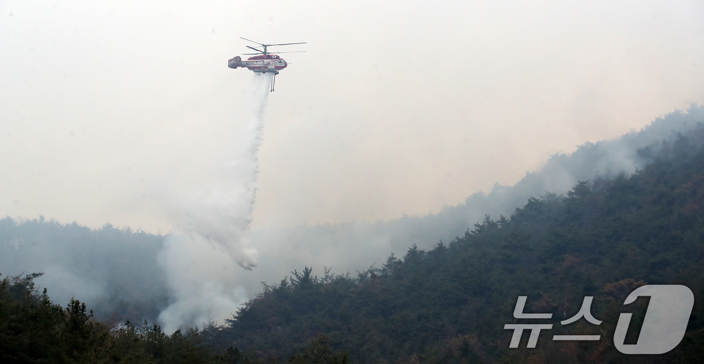 (밀양=뉴스1) 윤일지 기자 = 경남 밀양 산불 이틀째인 24일 오전 삼랑진읍 검세리 산불 현장에서 산불진화 헬기가 진화 작업을 벌이고 있다. 2026.2.24/뉴스1