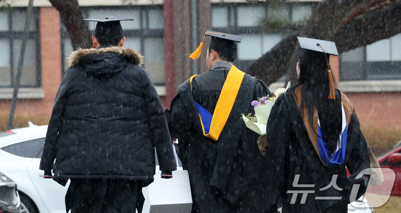 (완주=뉴스1) 유경석 기자 = 24일 전북 완주군 우석대학교에서 졸업생들이 내리는 진눈깨비에 발걸음을 재촉하고 있다. 2026.2.24/뉴스1