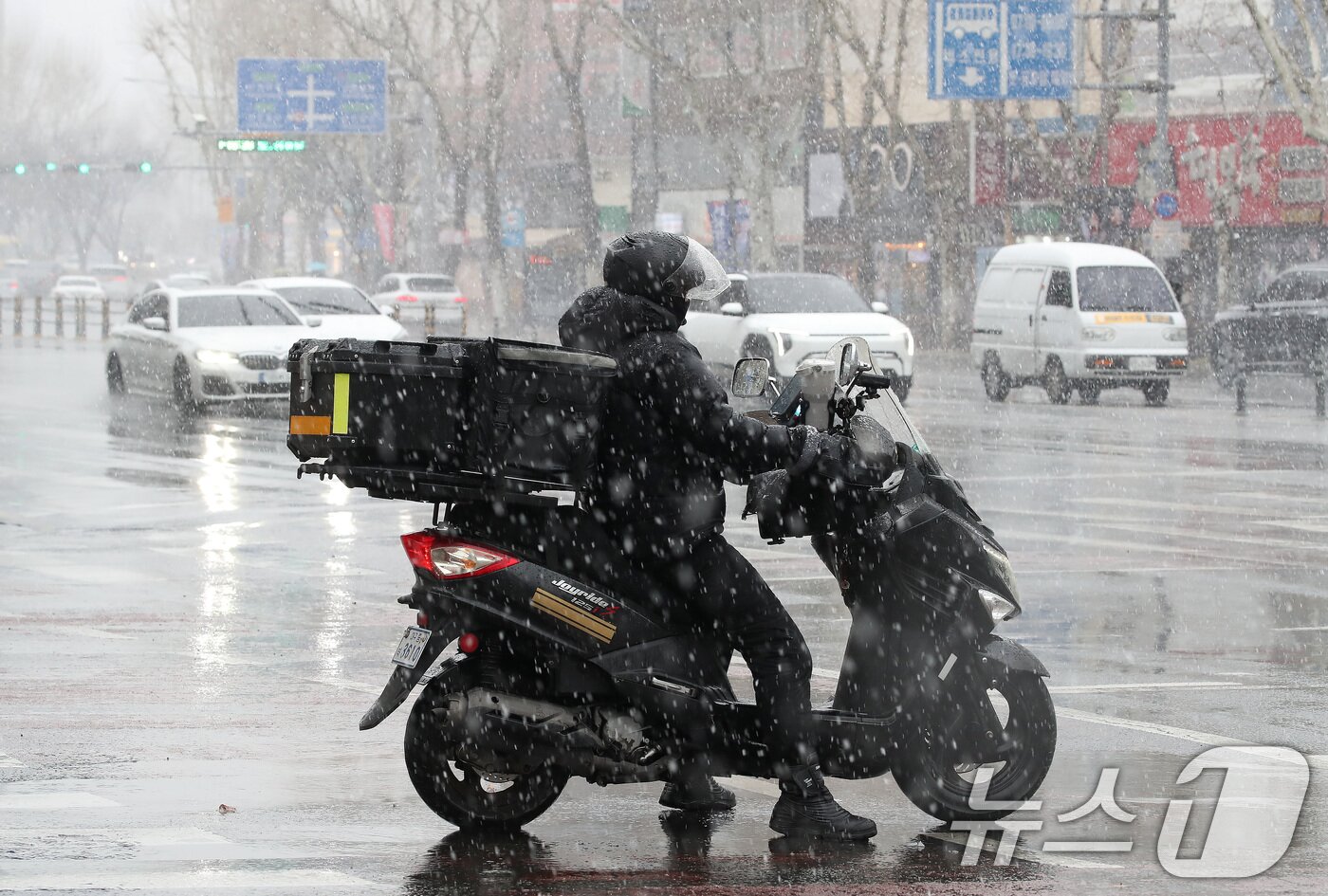 본문 이미지 - 24일 오후 대구 수성구 대구은행네거리 인근에 갑작스레 많은 눈이 내리는 가운데 배달 라이더가 신호 대기 중 눈을 맞고 있다. 2026.2.24 ⓒ 뉴스1 공정식 기자