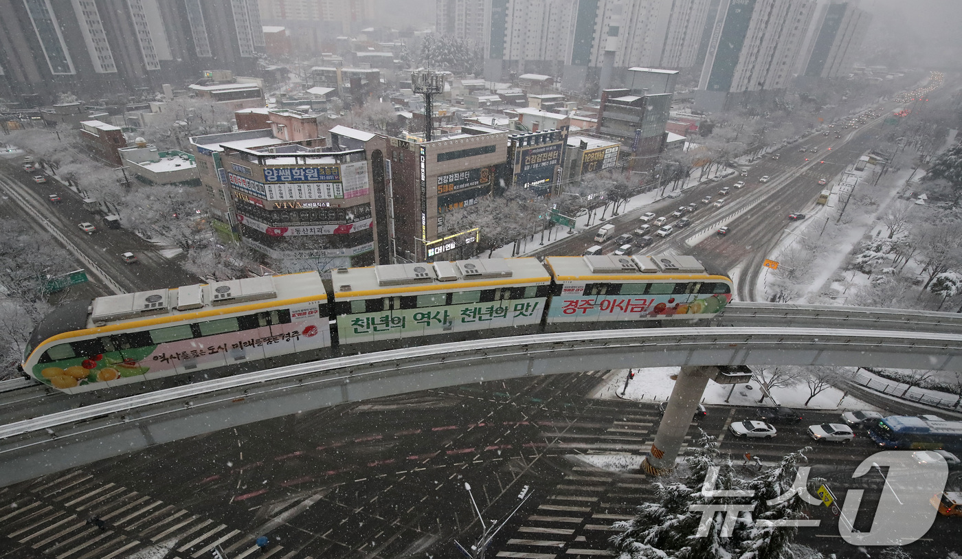 (대구=뉴스1) 공정식 기자 = 24일 오후 대구 도심에 함박눈이 내리는 가운데 '하늘열차'로 불리는 대구도시철도 3호선(모노레일) 열차가 수성구 범물동 인근을 지나고 있다. 20 …