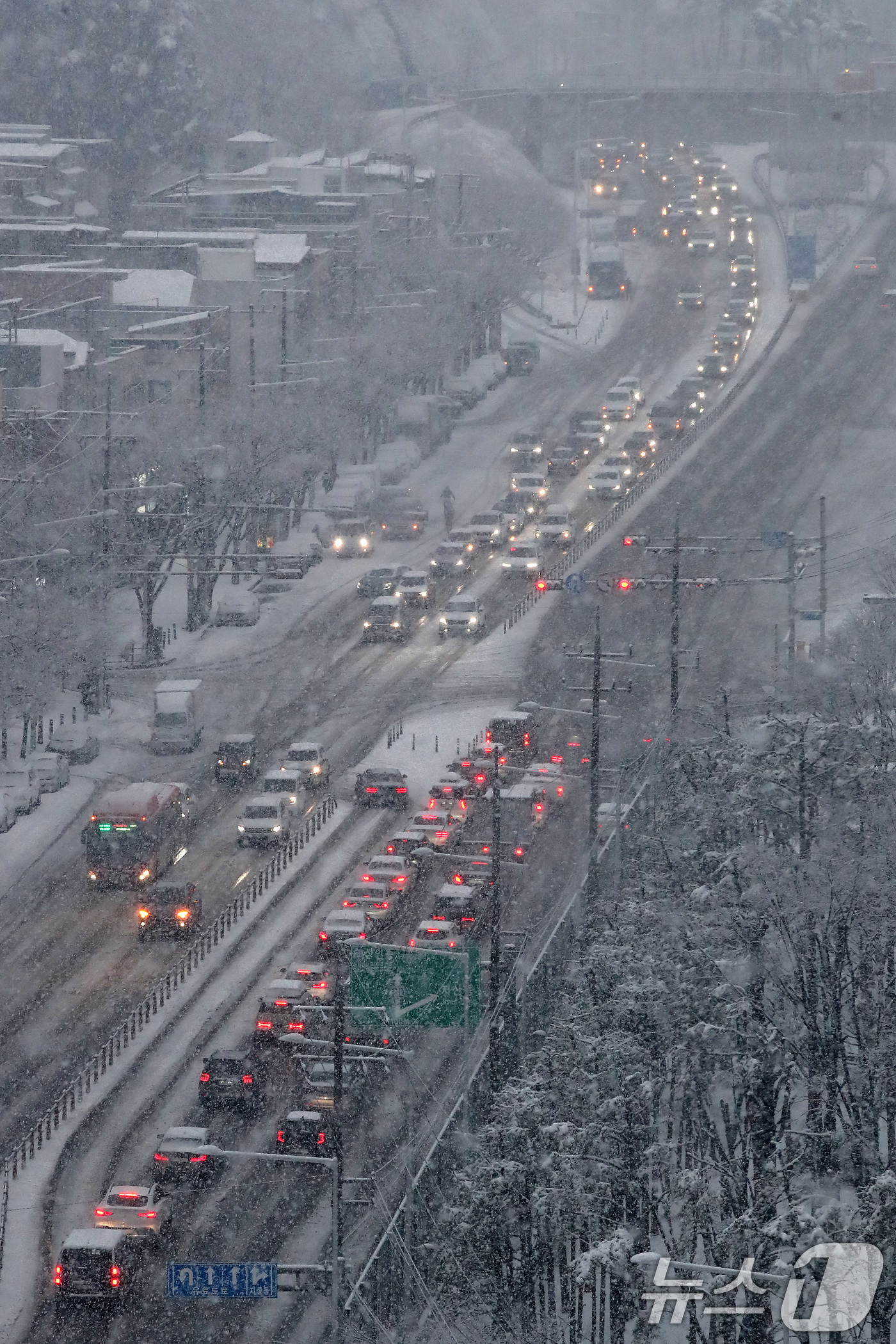 (대구=뉴스1) 공정식 기자 = 24일 오후 대구 수성구 범안로 앞산터널 방면 차량이 함박눈에 갇혀 정체를 빚고 있다. 2026.2.24/뉴스1