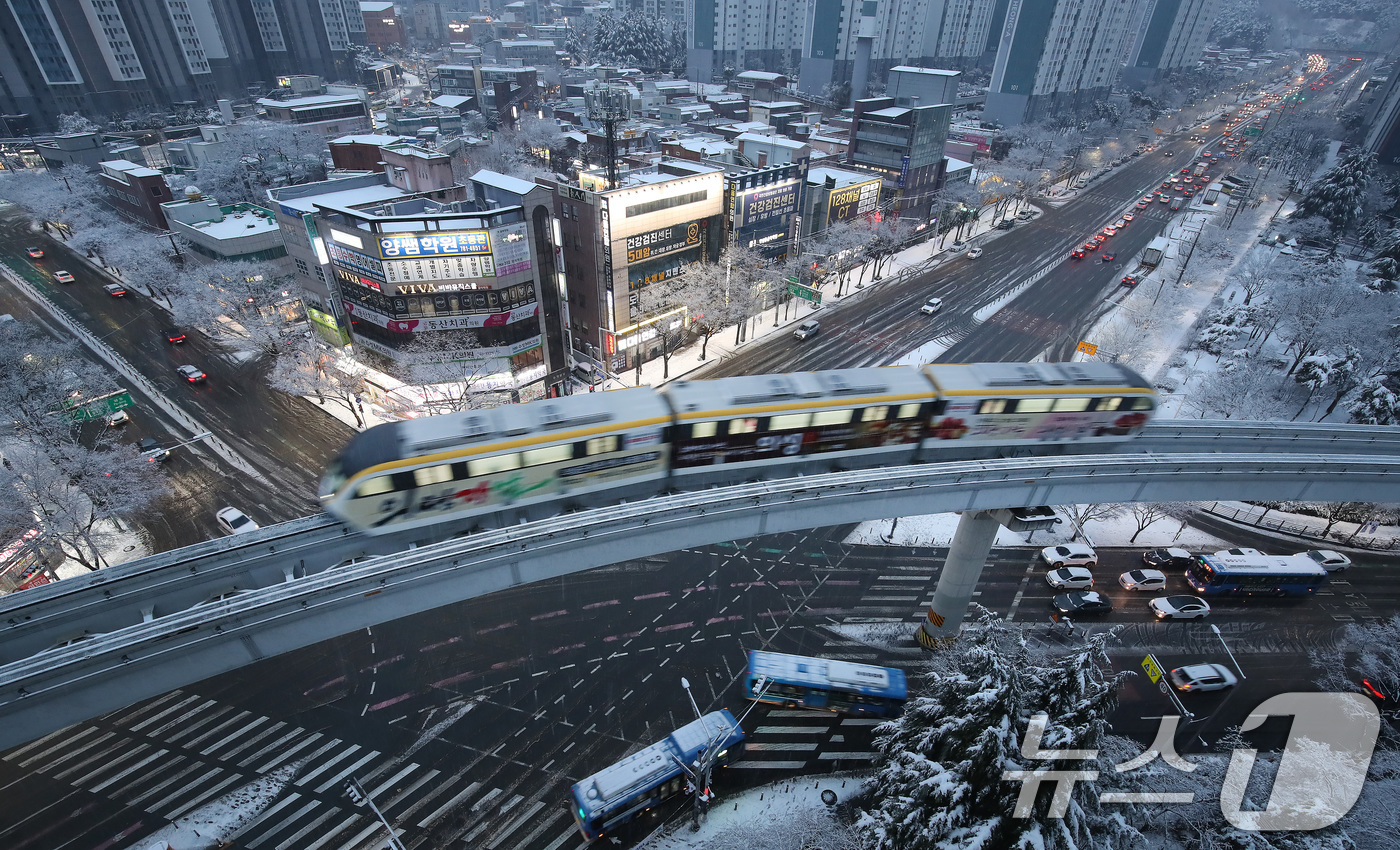 (대구=뉴스1) 공정식 기자 = 24일 오후 대구 도심에 함박눈이 내리는 가운데 '하늘열차'로 불리는 대구도시철도 3호선(모노레일) 열차가 수성구 범물동 인근을 지나고 있다. 20 …