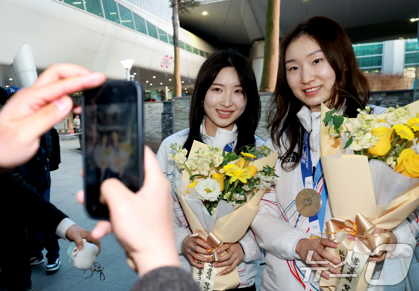 (인천공항=뉴스1) 이호윤 기자 = 쇼트트랙 여자 3000m 계주 금메달리스트인 김길리와 최민정이 24일 인천국제공항을 통해 귀국해 기념촬영을 하고 있다. 2026.2.24/뉴스1 …