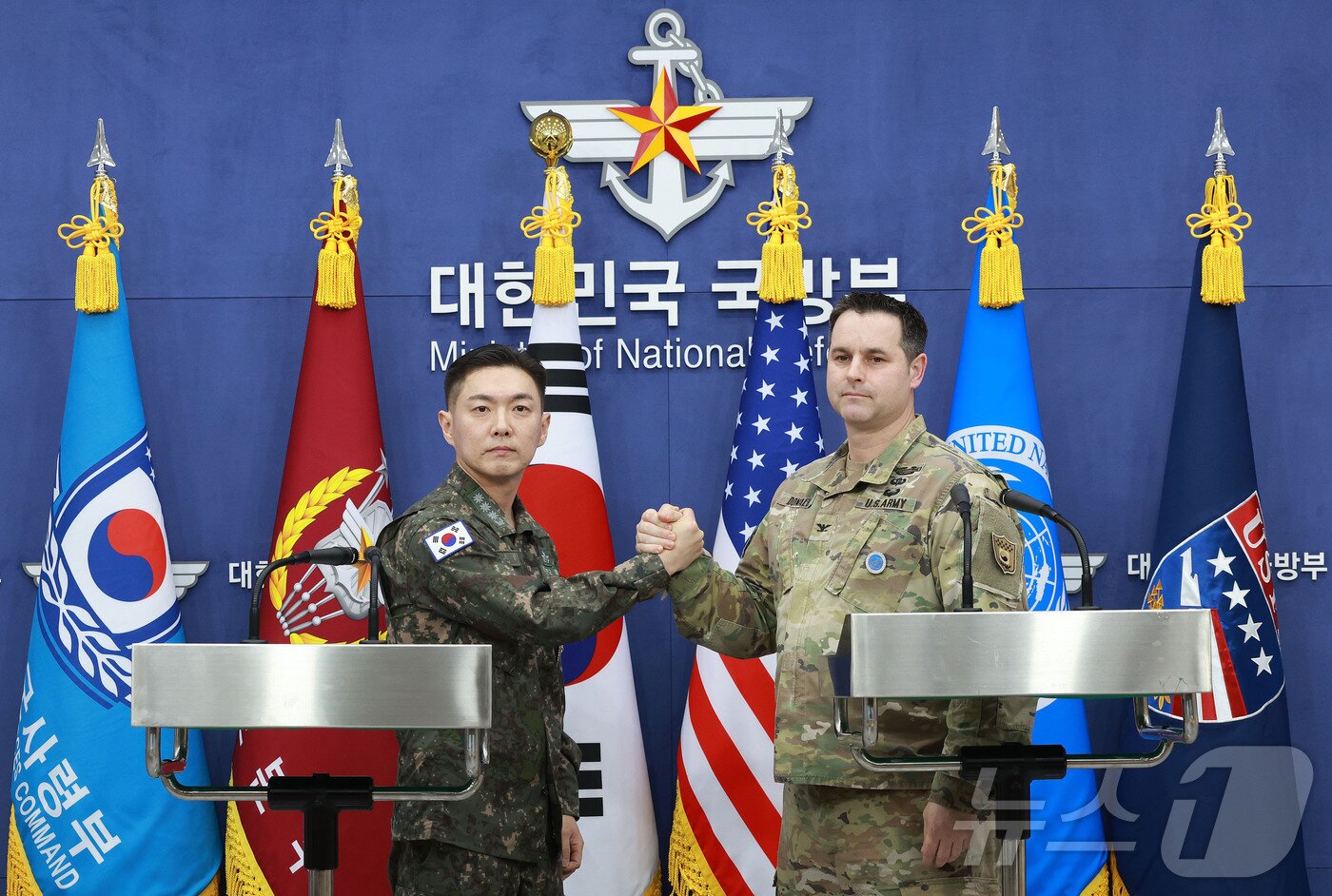 본문 이미지 - 장도영 합동참모본부 공보실장과 라이언 도날드 주한미군사 공보실장이 지난달 25일 오후 서울 용산구 국방부에서 2026 자유의 방패(FS) 연습 계획을 발표한 후 손을 맞잡고 있다. 2026.2.25 ⓒ 뉴스1 사진공동취재단