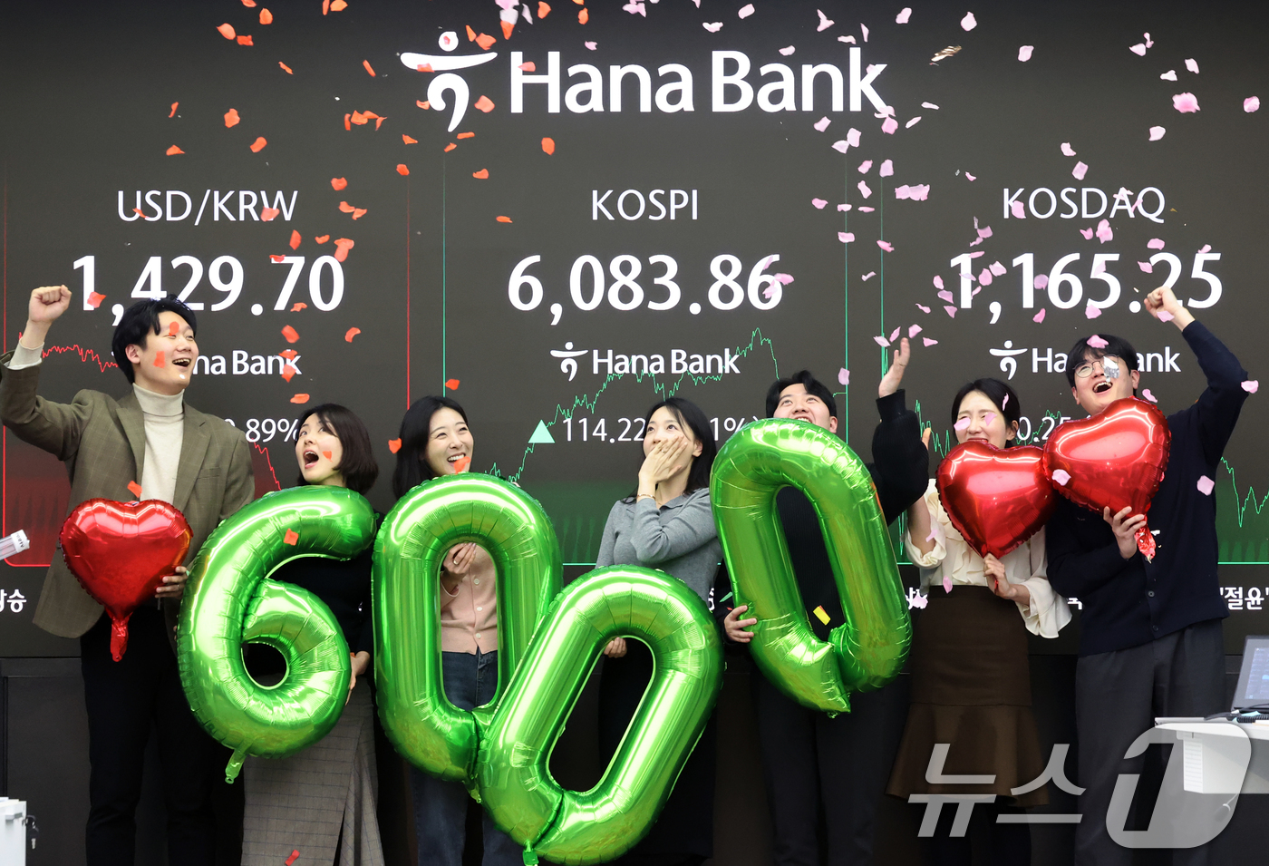 (서울=뉴스1) 황기선 기자 = 코스피가 종가 기준 사상 처음 6000선을 돌파한 25일 오후 서울 중구 하나은행 본점 딜링룸에서 직원들이 축하 세리머니를 하고 있다.이날 코스피지 …