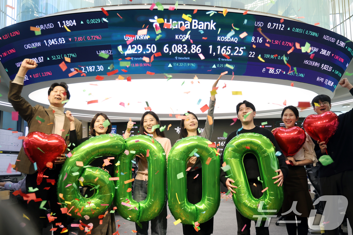 (서울=뉴스1) 황기선 기자 = 코스피가 종가 기준 사상 처음 6000선을 돌파한 25일 오후 서울 중구 하나은행 본점 딜링룸에서 직원들이 축하 세리머니를 하고 있다.이날 코스피지 …