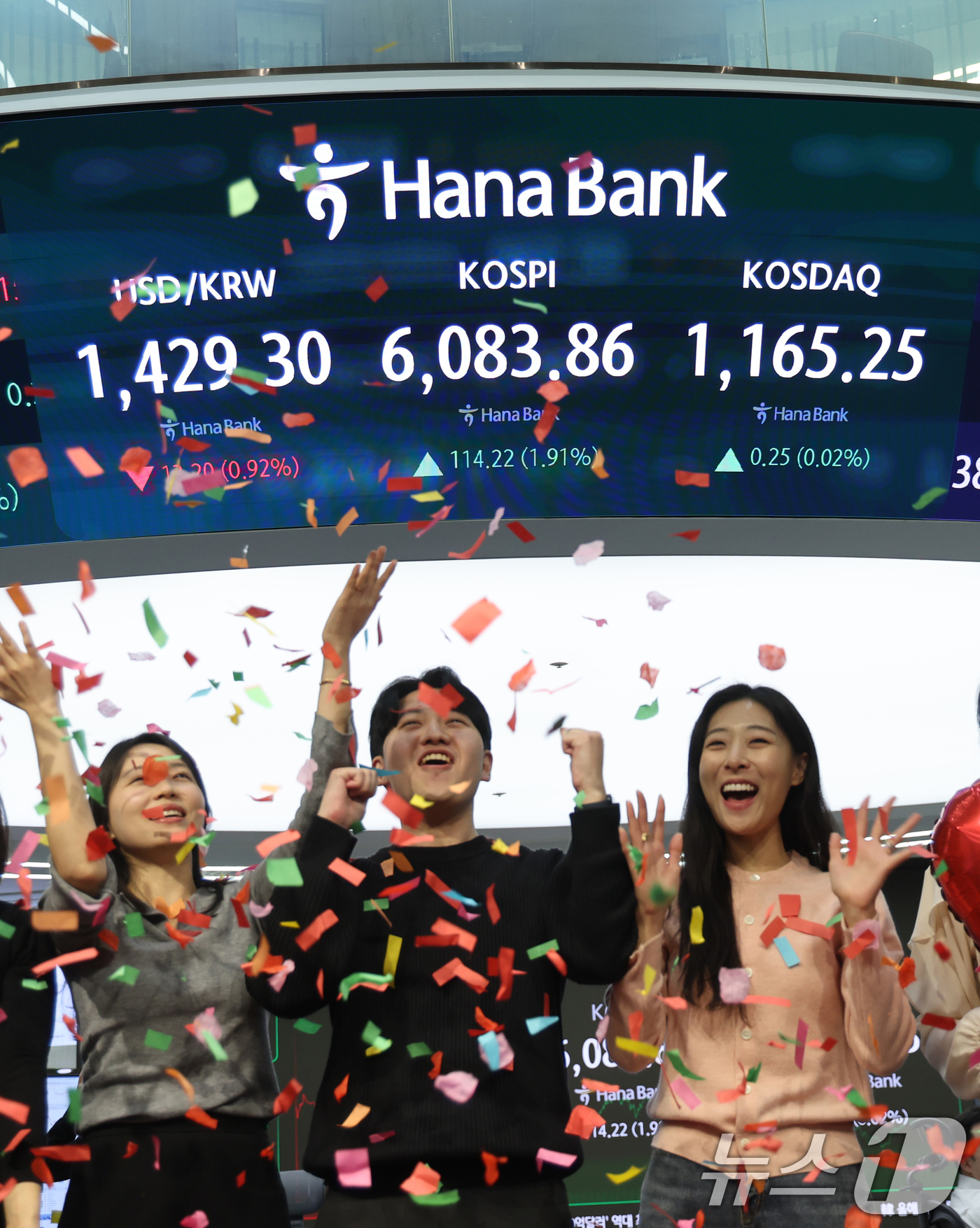 (서울=뉴스1) 황기선 기자 = 코스피가 종가 기준 사상 처음 6000선을 돌파한 25일 오후 서울 중구 하나은행 본점 딜링룸에서 직원들이 축하 세리머니를 하고 있다.이날 코스피지 …