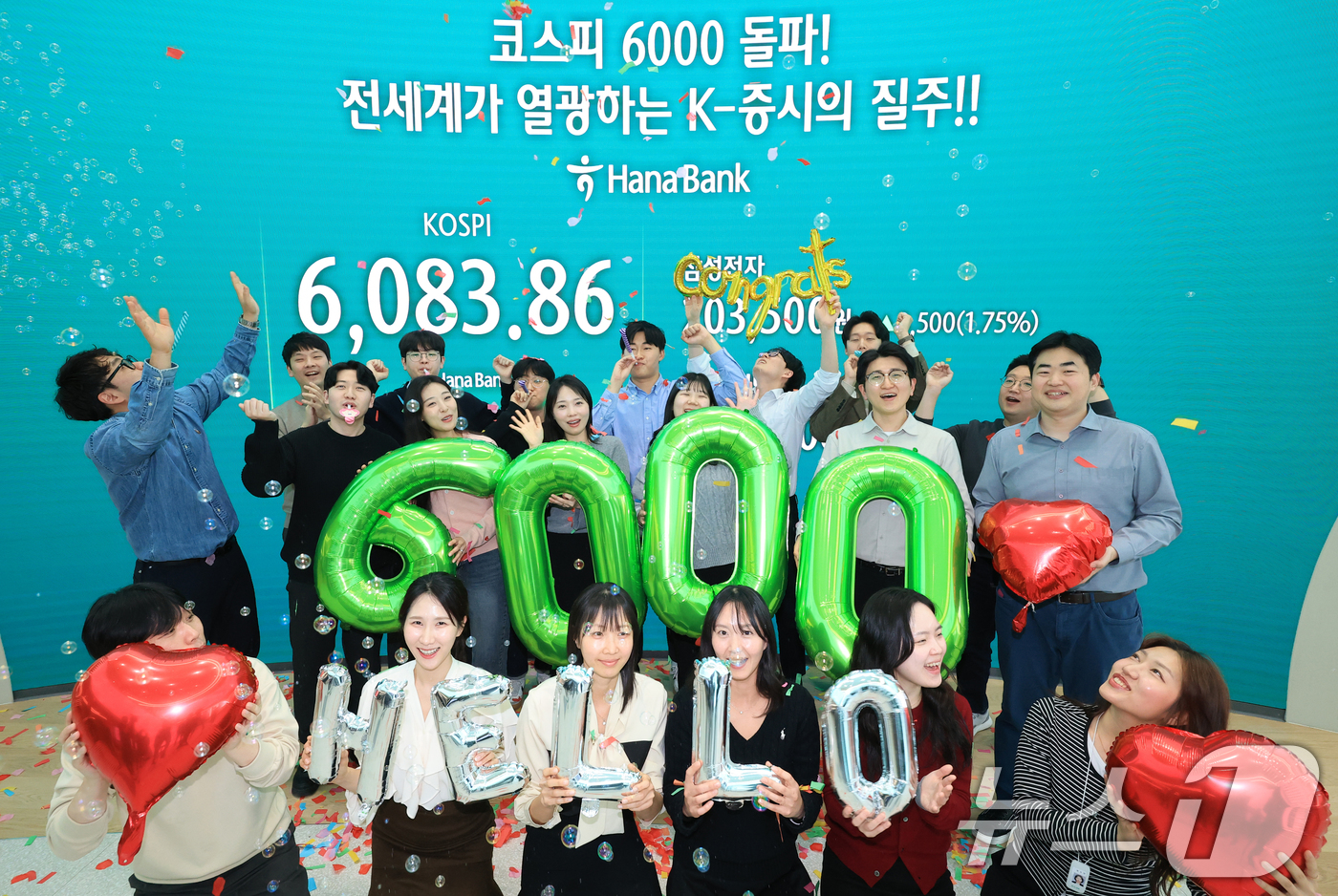 (서울=뉴스1) 황기선 기자 = 코스피가 종가 기준 사상 처음 6000선을 돌파한 25일 오후 서울 중구 하나은행 본점 딜링룸에서 직원들이 축하 세리머니를 하고 있다.이날 코스피지 …