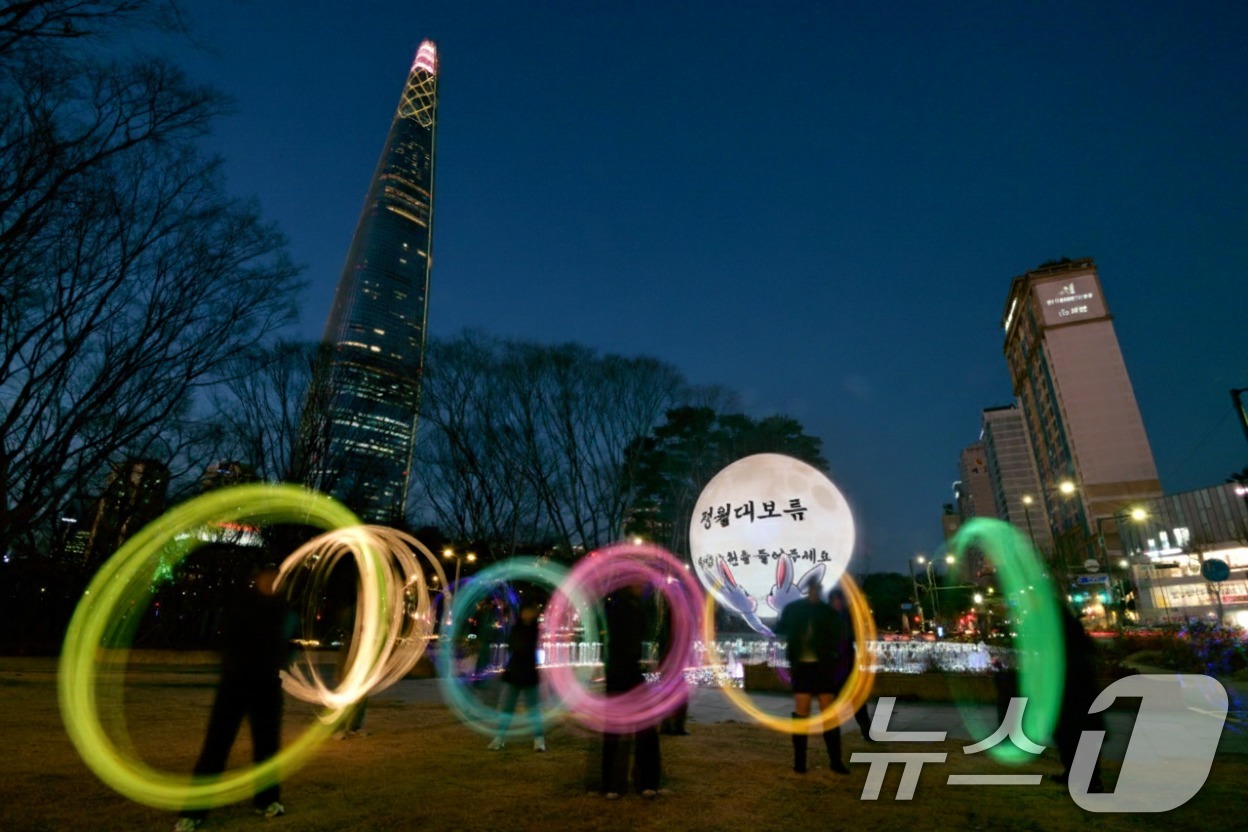 (서울=뉴스1) = 정월대보름을 앞둔 25일 서울 송파구 석촌호수 더스피어(The Sphere)에서 열린 쥐불놀이 행사에서 시민들이 쥐불놀이 체험을 하고 있다.송파구는 정월대보름을 …