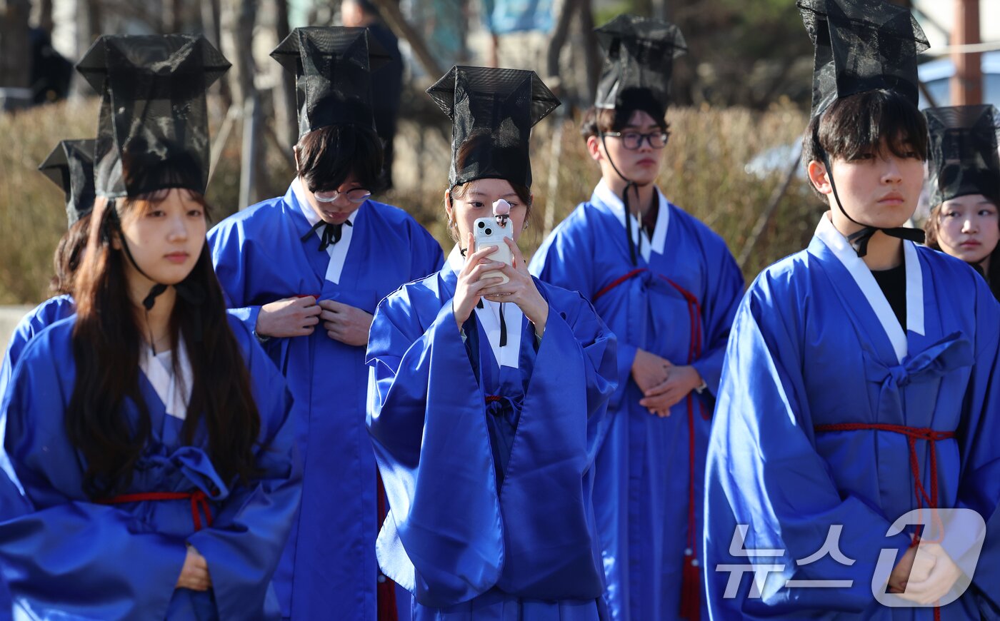 본문 이미지 - 26일 오전 서울 종로구 성균관대학교 비천당에서 열린 2026학년도 성균관대 입학 고유례(告由禮)에서 한 신입생이 스마트폰 카메라로 추억을 남기고 있다.  2026.2.26 ⓒ 뉴스1 오대일 기자