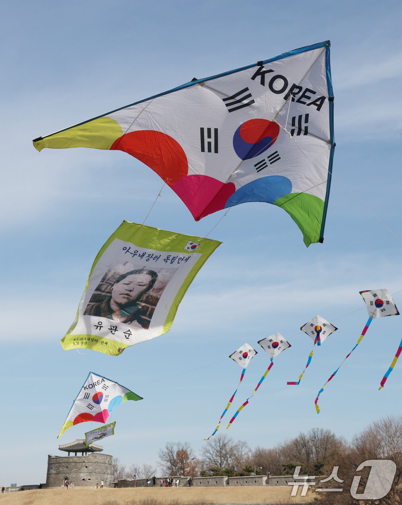 본문 이미지 - 제107주년 3·1절을 사흘 앞둔 26일 경기 수원시 팔달구 수원화성 창룡문에서 한국연연맹 회원들이 독립운동가들의 모습이 담긴 연을 날리고 있다. 2026.2.26 ⓒ 뉴스1 김영운 기자