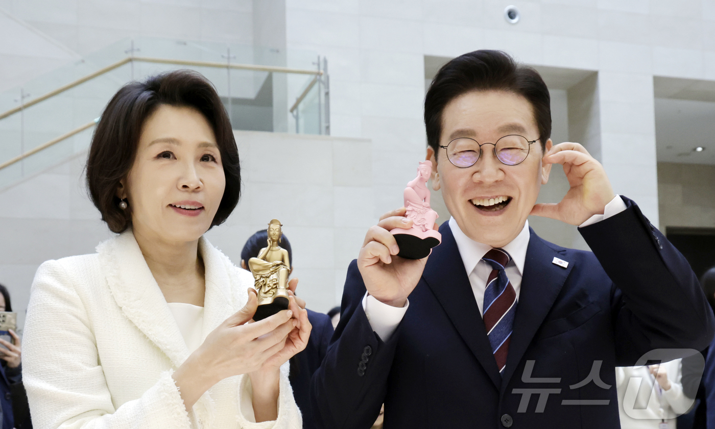(서울=뉴스1) 허경 기자 = 이재명 대통령과 김혜경 여사가 26일 서울 용산구 국립중앙박물관에서 열린 특별전 '우리들의 이순신'을 관람한 뒤 기념품을 들고 기념촬영을 하고 있다. …