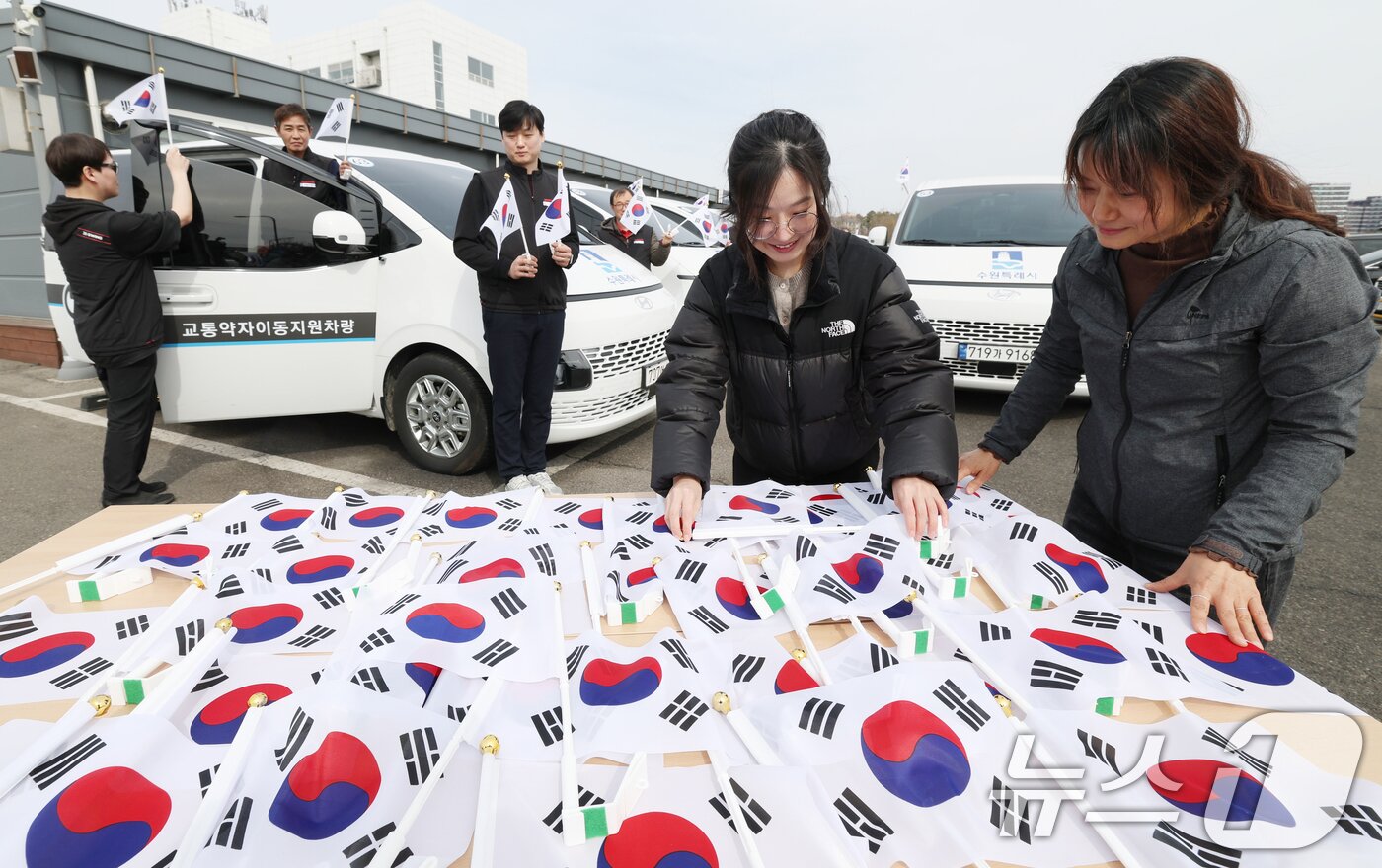 본문 이미지 - 제107주년 3·1절을 사흘 앞둔 26일 경기 수원시 권선구 수원시교통약자지원센터 한아름콜에서 직원들이 3·1절을 맞아 교통약자지원차량에 부착할 태극기를 준비하고 있다. 2026.2.26 ⓒ 뉴스1 김영운 기자