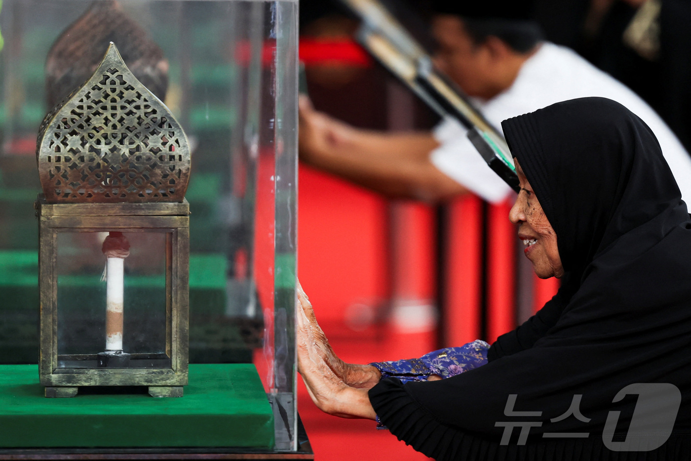 (보고르 로이터=뉴스1) 이정환 기자 = 25일, 인도네시아 서자바주 보고르의 한 스포츠홀에서 열린 '예언자 무함마드 유물 전시회'에서 세티아 루펜시(83세)가 유물의 유리 진열장 …