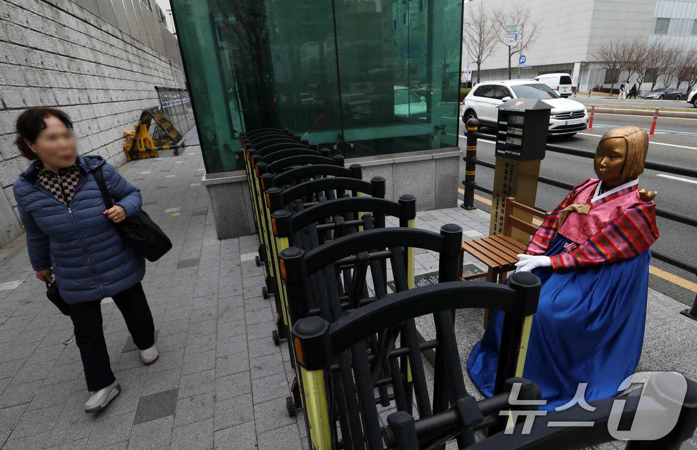 (부산=뉴스1) 윤일지 기자 = 3·1절을 사흘 앞둔 26일 부산 동구 일본영사관 앞에서 시민이 전통 한복이 입혀진 평화의 소녀상을 보며 길을 걷고 있다.  2026.2.26/뉴스 …