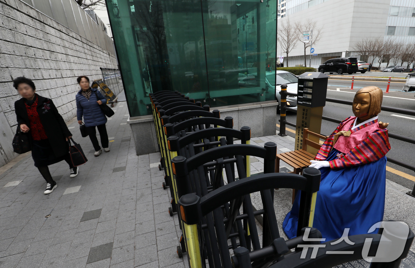 (부산=뉴스1) 윤일지 기자 = 3·1절을 사흘 앞둔 26일 부산 동구 일본영사관 앞에서 시민들이 전통 한복이 입혀진 평화의 소녀상을 보며 길을 걷고 있다.  2026.2.26/뉴 …