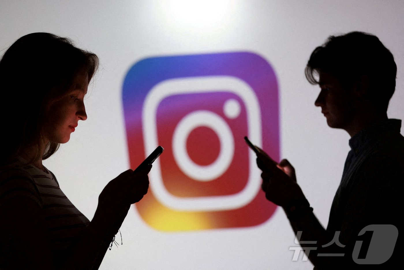 (제니차 로이터=뉴스1) 이창규 기자 = 10대들이 인스타그램 로고 앞에서 스마트폰을 들고 포즈를 취하고 있는 일러스트 이미지. 2025.10.20./뉴스1ⓒ 로이터=뉴스1