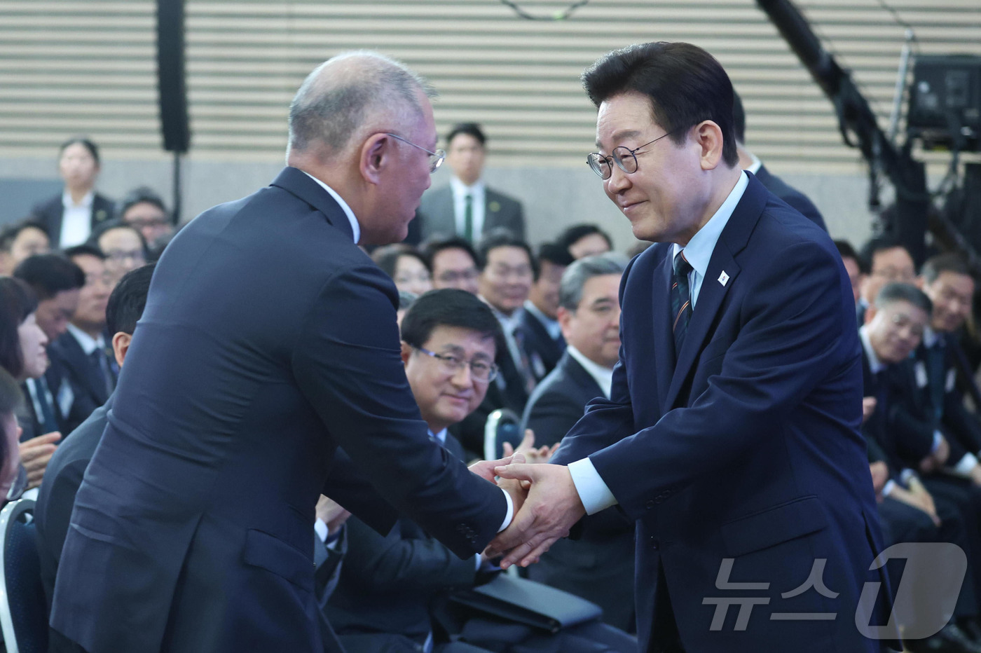 (군산=뉴스1) 이재명 기자 = 이재명 대통령이 27일 전북 군산시 새만금 컨벤션센터에서 열린 새만금 로봇·수소·AI 시티 투자협약식에서 정의선 현대자동차 회장과 악수를 하고 있다 …