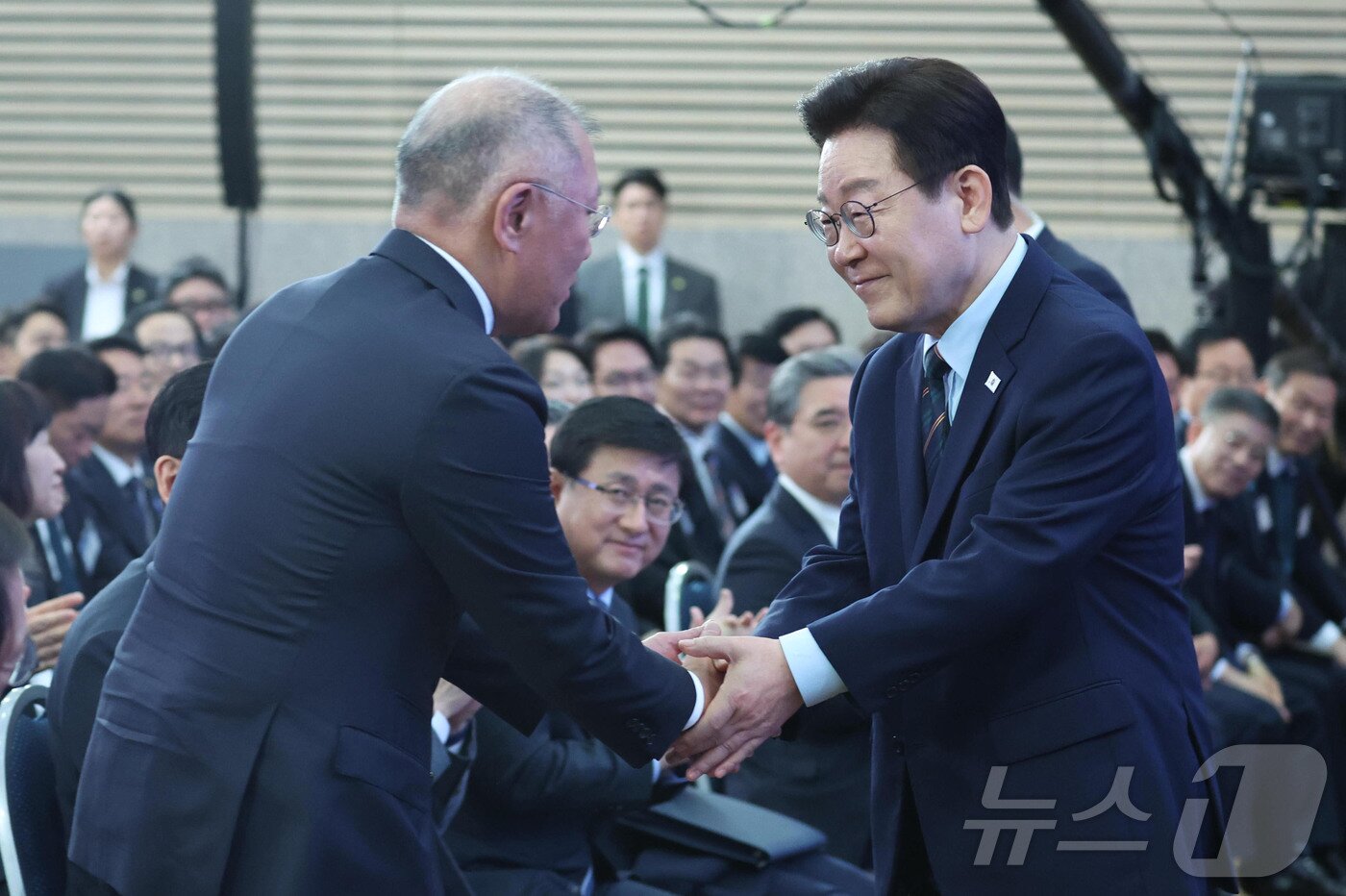 본문 이미지 - 이재명 대통령이 27일 전북 군산시 새만금 컨벤션센터에서 열린 새만금 로봇·수소·AI 시티 투자협약식에서 정의선 현대자동차 회장과 악수를 하고 있다. 2026.2.27 ⓒ 뉴스1 이재명 기자