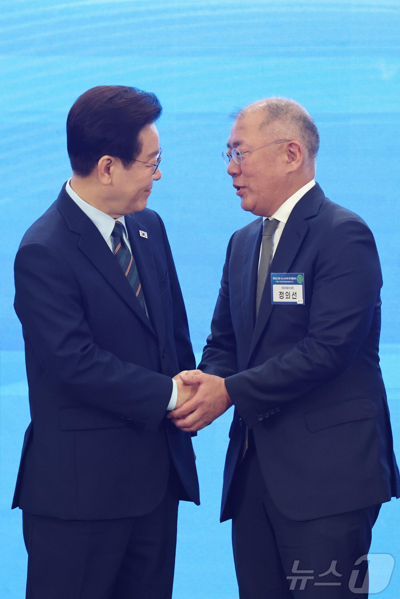 본문 이미지 - 이재명 대통령과 정의선 현대자동차 회장이 27일 전북 군산시 새만금 컨벤션센터에서 열린 새만금 로봇·수소·AI 시티 투자협약식에서 악수를 하고 있다. 2026.2.27 ⓒ 뉴스1 이재명 기자