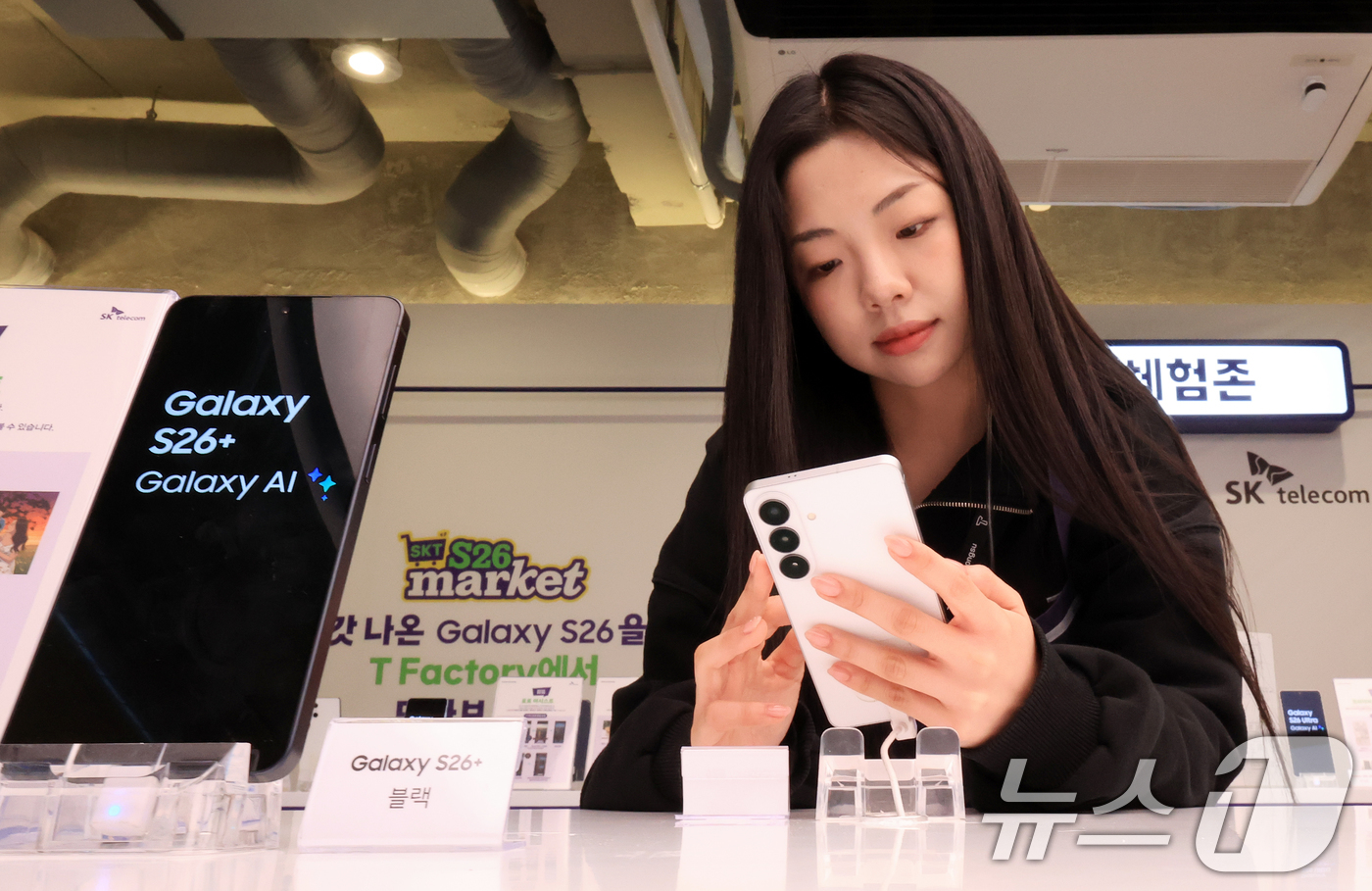 (서울=뉴스1) 이호윤 기자 = 갤럭시 S26 사전예약이 시작된 27일 서울 성동구 T팩토리에서 열린 ‘SKT S26 마켓 팝업스토어'에서 시민이 갤럭시 S26 시리즈를 살펴보고 …