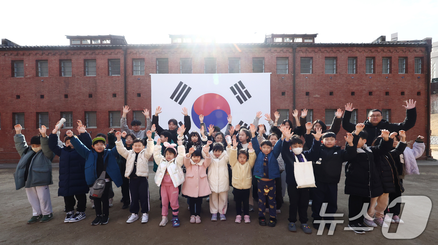 (서울=뉴스1) 김민지 기자 = 107주년 3.1절을 앞둔 27일 서울 서대문형무소역사관을 찾은 종합무예 영무관 소속 학생들과 어린이들이 대형 태극기 앞에서 사진을 찍고 있다. 2 …